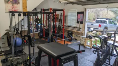 A picture of a garage homegym geared towards powerlifting and bodybuilding.